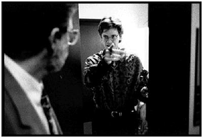Charles Amirkhanian looks back at a pointing David Harrington, seen through a doorway, (1995)