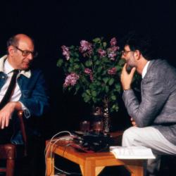 Three quarter length portrait of Mauricio Kagel and Charles Amirkhanian in discussion onstage during Speaking of Music at the Exploratorium, San Francisco (1988)