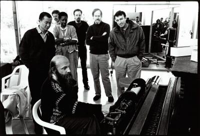 Rex Lawson sitting at his pianola while other composers observe, standing, Woodside CA, (1995)