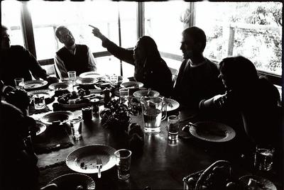 A group portrait of OM 4 artists seated at a dining table, observing while Pamela Z talks, Woodside, CA (1997)