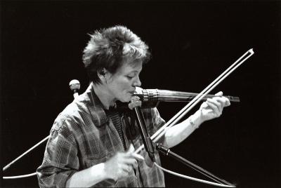 Laurie Anderson, head and shoulders portrait, facing right, playing the violin, (1996)
