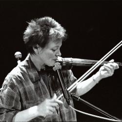 Laurie Anderson, head and shoulders portrait, facing right, playing the violin, (1996)
