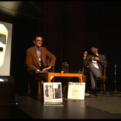 Charles Amirkhanian and David Rosenboom seated onstage during Speaking of Music at the Exploratorium, San Francisco (1986)