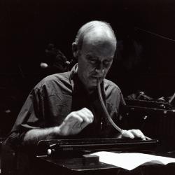 Christian Wolff, head and shoulders portrait, facing forward, playing melodica, San Francisco, 2000 (cropped image) 