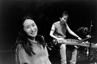 Ji Young Yi, heads and shoulders portrait, facing forward, and Hyo-shin Na, full length portrait, seated with instrument, facing forward, San Francisco CA, (2000)