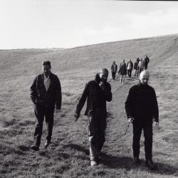 Peter Garland, Paul D. Miller, and Robin Rimbaud walking, along with other OM 6 artists, Woodside, 2000 (cropped image)