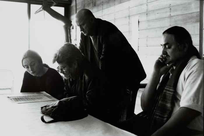 Aleksandra Vrebalov, James Tenney, and Gavin Bryars read a score, while Glen Velez sits with eyes closed, Woodside, CA (2001)
