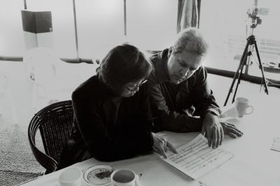Half length portrait of Hi Kyung Kim and Chris Brown, seated, reviewing a score, Woodside, CA (2001)