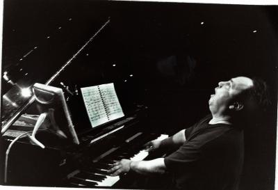 William Winant, half length portrait, playing piano, head tilted up and facing left, San Francisco CA, (2001)