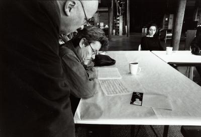 Gavin Bryars, standing, and James Tenney, seated at table , look at a score, Woodside, CA (2001)