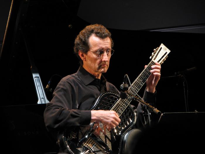 John Schneider, half length portrait, facing slightly right, playing a refretted National Steel Guitar, San Francisco CA., (2009)