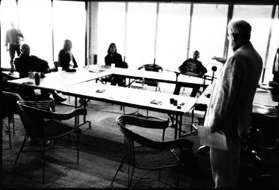 Tom Johnson, standing, facing away and to the left, addressing fellow OM 15 composers, seated around table, Woodside CA., (2010)