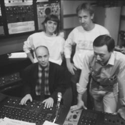 KPFA staff with Brian Eno by the control board in the KPFA studio, 1988