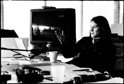 Lisa Bielawa, half length portrait, facing left, seated at table with microphone, giving a presentation, Woodside CA., (2010)