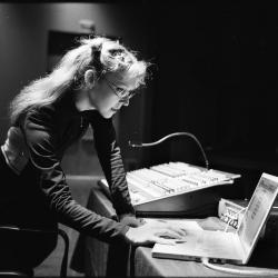 Natasha Barrett, three quarter length portrait, standing, facing right and slightly down at computer, San Francisco CA., vs 2 (2010)