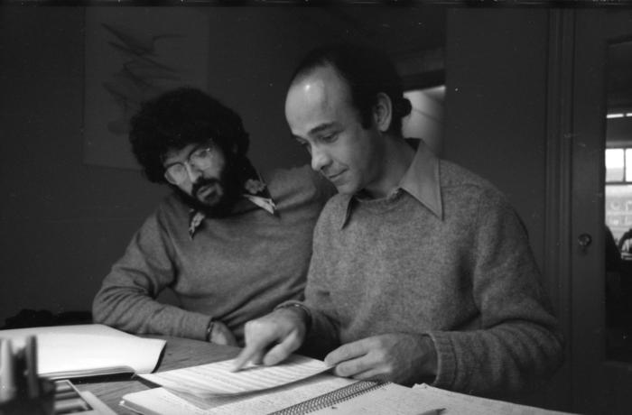 Charles Amirkhanian and Charles Dodge, half-length portrait, seated at desk examining a musical score