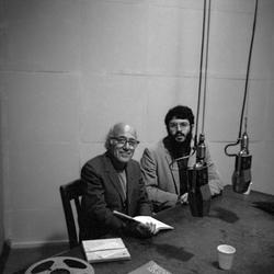 Carl Rakosi and Charles Amirkhanian, seated at a table, in a KPFA broadcast booth, 1971