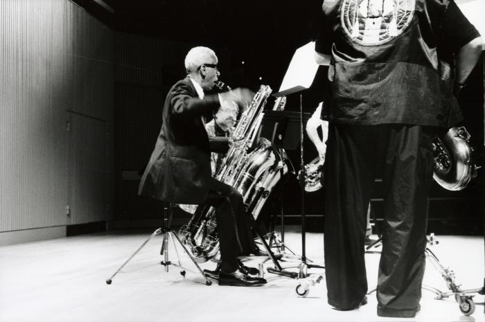 Roscoe Mitchell, seated, playing bass saxophone during a rehearsal for OM 19 (2014)