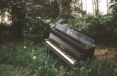 A Bord piano sitting in the overgrown greens of Annea Lockwood's backyard, Ingatestone (1972)