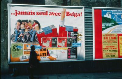 Image of a woman standing in front of a large billboard advertising cigarettes, Paris, France, 1976