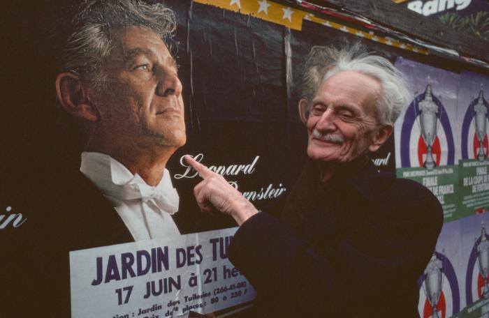 Ivan Wyschnegradsky posing next to a billboard image of Leonard Bernstein, Paris, vs. 3 (1976)