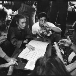 Philip Glass, Meredith Monk, Jon Jang, Julia Wolfe, and Trimpin, seated around a musical score, 1993