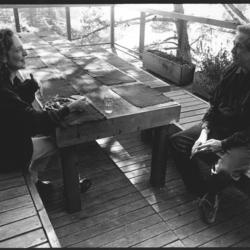 Julia Wolfe and Thomas Buckner seated across from each other at a table, outdoors in Woodside, CA (1993)