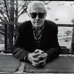 Portrait of Robert Ashley seated at an outside table during the Djerassi Resident Artists Program in Woodside, CA (1993)