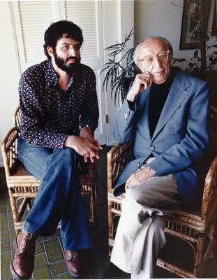 Charles Amirkhanian & Aaron Copland, full length portrait, seated, facing forward, Aptos CA, 1978