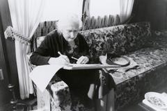 Pauline Ornstein, seated, examining a document, Brownsville TX, 1981